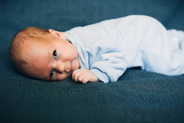 Újszülött fiú feküdt kék ruhával — Stock Fotó