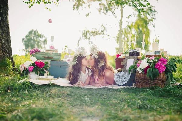 Happy mother and daughter lying on a blanket outdoors on a Sunny summer — Stock Photo, Image