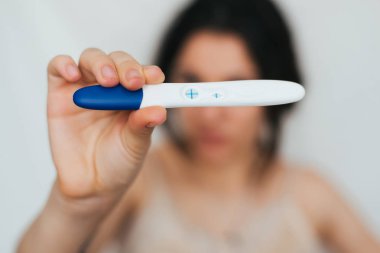 mutlu kız elinde pozitif gebelik testi