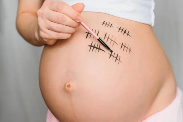 Fille enceinte peint terme de grossesse sur son ventre — Photo