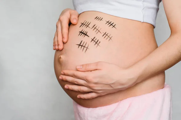 Ventre d'une fille enceinte avec peint pour une période de grossesse — Photo