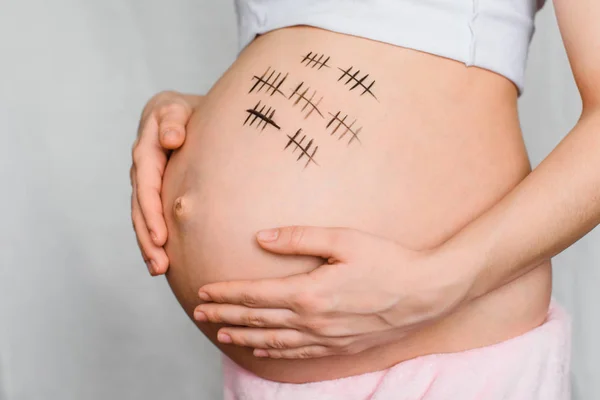 Fille enceinte étreint son estomac avec un terme de grossesse — Photo