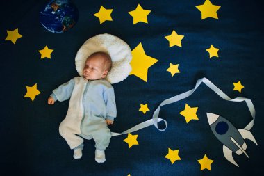 arka plan gökyüzü üzerinde uyuyan bebek çocuk astronot