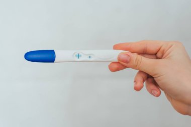 bir kızın elinde pozitif gebelik testi