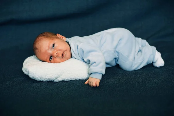 Stock image newborn baby boy lying on white plush pillow