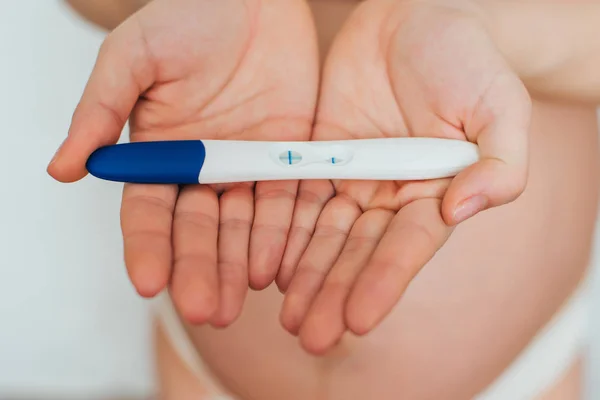 Test de grossesse dans les mains d'une fille avec un résultat positif — Photo