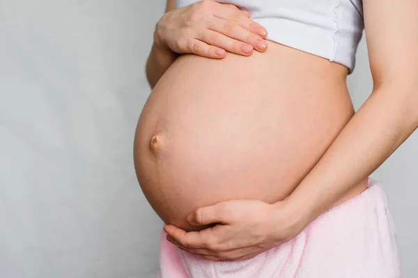 Incinta ragazza delicatamente abbracciando il suo ventre — Foto Stock