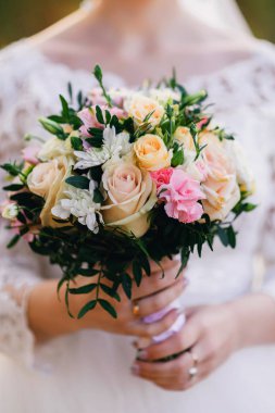 gelinin elinde güzel düğün buket sarı gül, beyaz kasımpatı ve Alstroemeria