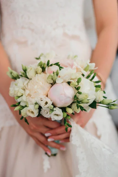 Braut hält einen zarten eleganten Brautstrauß mit weißen Pfingstrosen — Stockfoto