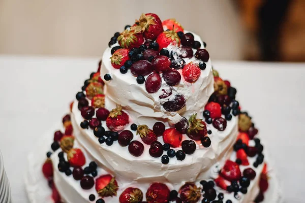 Pastel de boda crema blanca con fresas dulces, cerezas, arándanos, grosellas negras —  Fotos de Stock