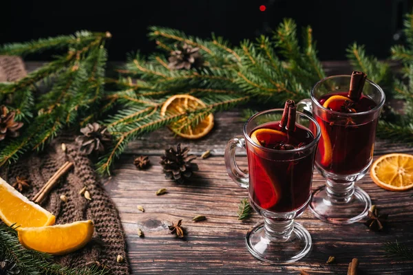 Mug of christmas mulled wine with spices and orange slices on rustic table