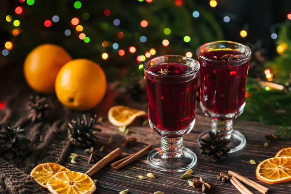 Dos copas con vino caliente en la mesa con rodajas de naranja y especias — Foto de Stock