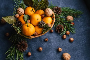 Çam kozalaklarıyla süslenmiş mandalina, ceviz ve fındık