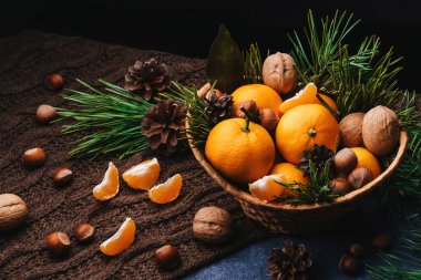 Çam kozalaklarıyla süslenmiş mandalina, ceviz ve fındık
