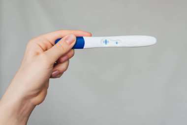bir kızın elinde pozitif gebelik testi