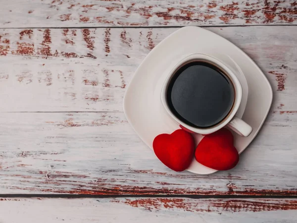 Tasse Kaffee und Herzen auf einem Holztisch. Konzept des Morgenfrühstücks am Valentinstag — Stockfoto