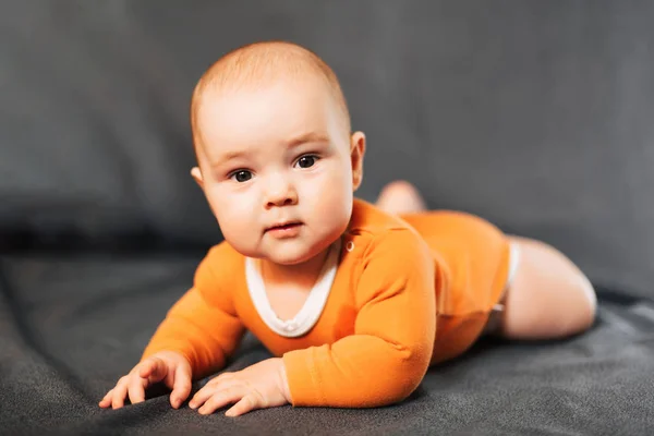 O rapazinho está a mentir e a olhar para a câmara. Retrato de um bebê recém-nascido — Fotografia de Stock