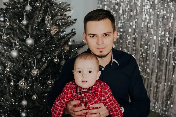 Petit garçon enfant dans les bras de son père sur le fond de l'arbre de Noël — Photo