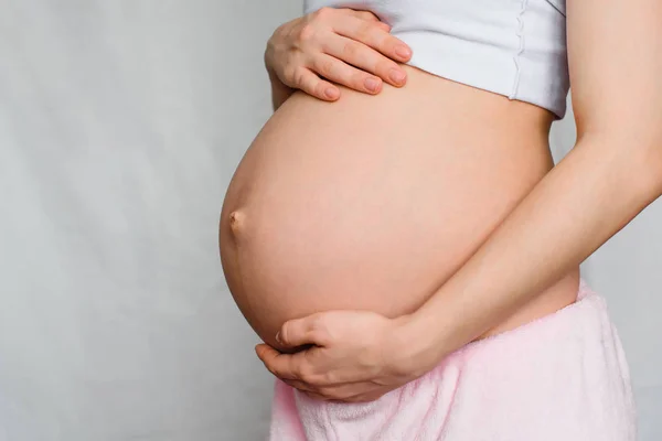 Incinta ragazza delicatamente abbracciando il suo ventre — Foto Stock