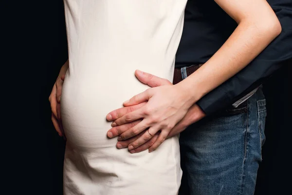 Mężczyzna przytula brzuch dziewczyny w ciąży. Para spodziewa się dziecka — Zdjęcie stockowe
