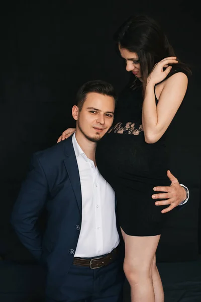 Coppia incinta che abbraccia. Gli amanti alla moda giovane uomo e donna — Foto Stock