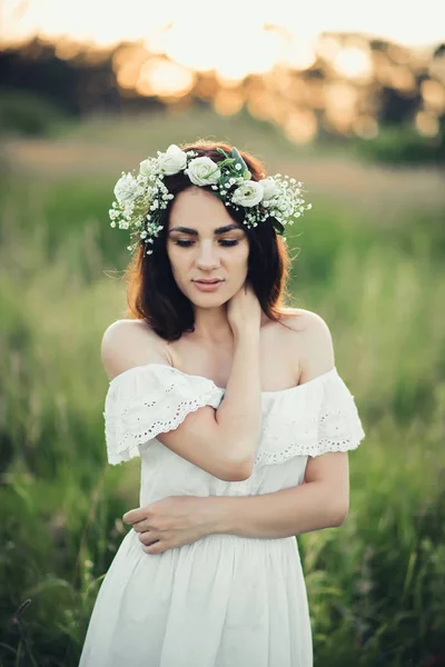Fehér ruha, és a virág koszorú a vonzó barna lány portréja — Stock Fotó
