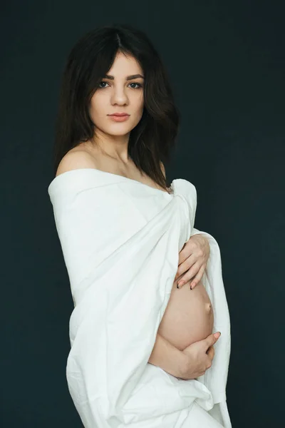 Embarazada joven hermosa chica morena en tela blanca —  Fotos de Stock