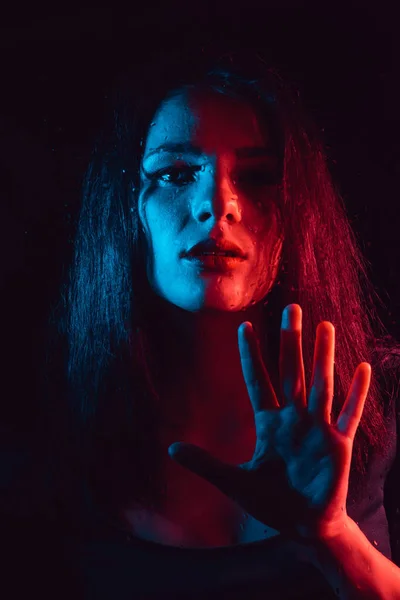 Sensual portrait of a beautiful attractive girl looking through the glass with raindrops — Stock Photo, Image