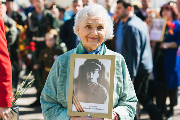 VICHUGA, RUSSIA - MAY 9, 2018: Portrait of a happy smiling old woman at parade in honor of victory in world war II. Immortal regiment