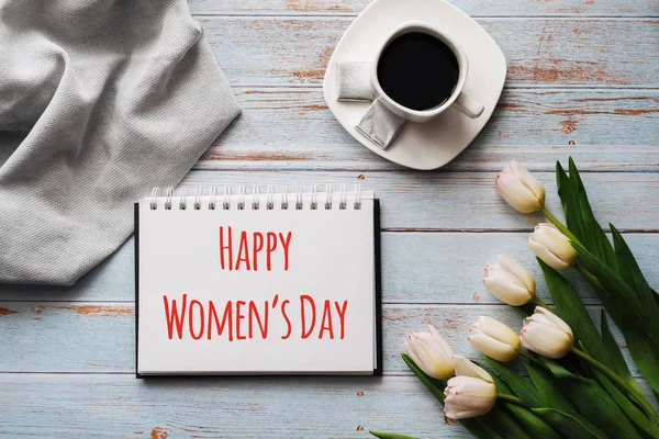 Cartão de felicitações com a inscrição Happy Womens Day. Buquê de flores brancas de tulipa com uma xícara de café — Fotografia de Stock