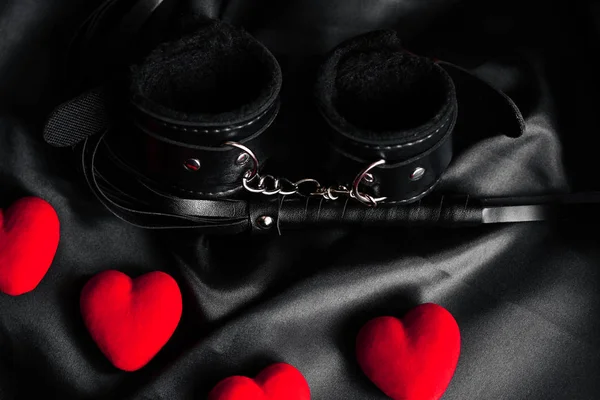 Наручники и кнут для БДСМ секса с красными сердцами . — стоковое фото