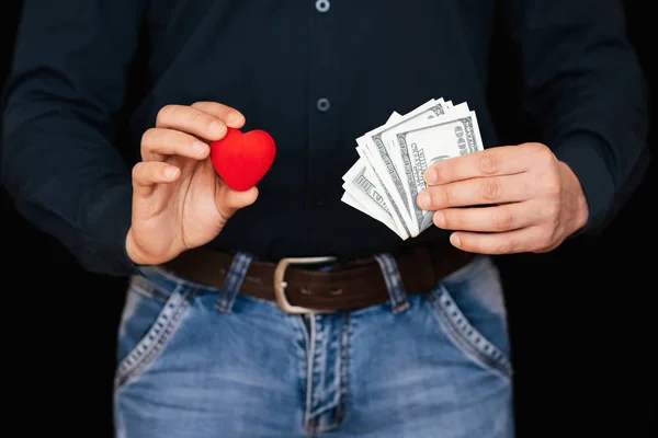 Dollar bills and a red heart in the hands of a man — Stock Photo, Image