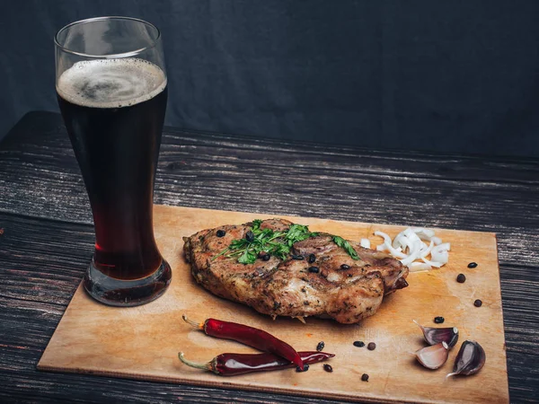 Sarımsak, biber, soğan ve bir bardak koyu bira ile domuz eti — Stok fotoğraf