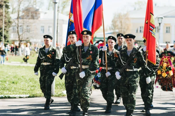 VICHUGA, RUSSIA - MAY 9, 2018: Young men in uniform at victory parade in world war II with flags — Stock Photo, Image