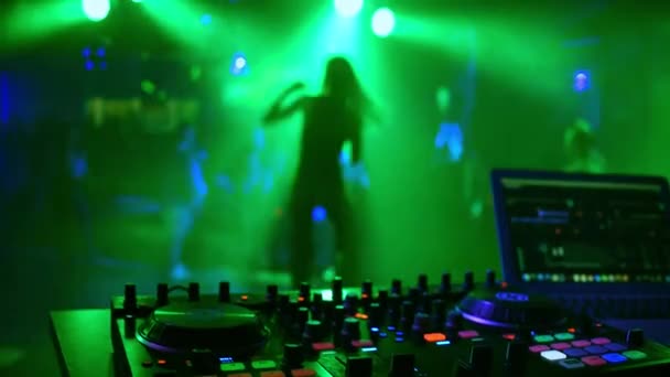 DJ mixer controller in discoteca con silhouette sfocata di ballerina cantante — Video Stock