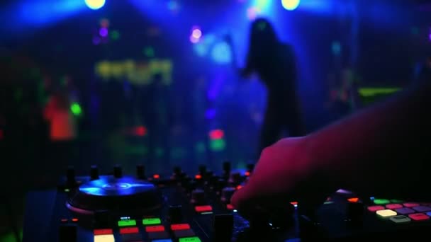 Mezclador controlador con DJ manos en discoteca con silueta borrosa de bailarina cantante — Vídeo de stock