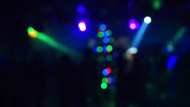 Siluetas borrosas de personas bailando en un club nocturno bajo la luz de colores de focos — Vídeos de Stock