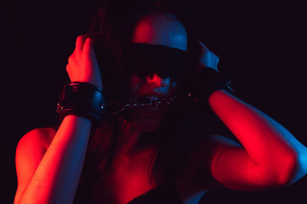 Лицо сексуальной девушки с кружевными повязками и кожаными наручниками БДСМ
