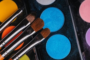 renkli göz gölgeler ile bir palet üzerinde makyaj fırçaları seti