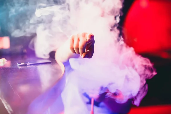 Ο άνθρωπος καπνίζει μια ρόμπα και αναπνέει ένα μεγάλο σύννεφο καπνού — Φωτογραφία Αρχείου