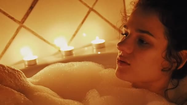 Bela jovem relaxa no banheiro com espuma — Vídeo de Stock