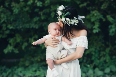 mutlu genç çekici anne yaz aylarında erkek bebek yenidoğan oğlu kucaklar