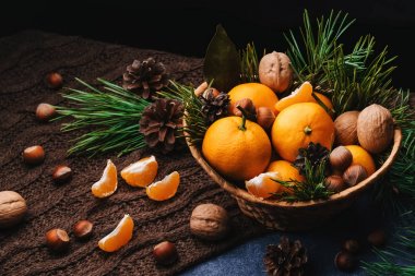 Çam kozalaklarıyla süslenmiş mandalina, ceviz ve fındık