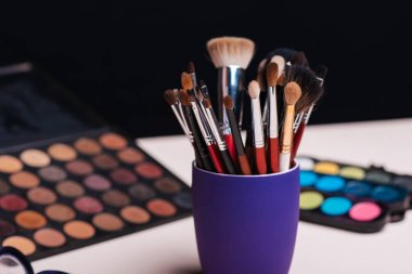 Göz farı paletinin arka planında makyaj fırçası seti