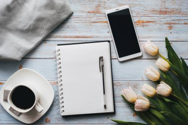 boş bir dizüstü bilgisayar, bir Fincan kahve ve ahşap bir arka plan üzerinde bir akıllı telefon ile lale buketi
