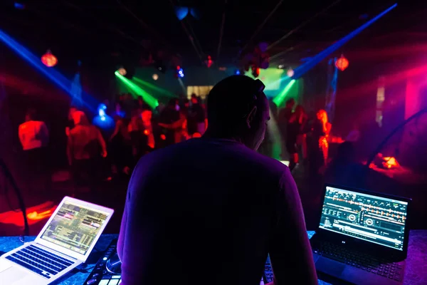 Bir gece kulübünde bir partide müzik karıştırma kulaklık geri Dj — Stok fotoğraf