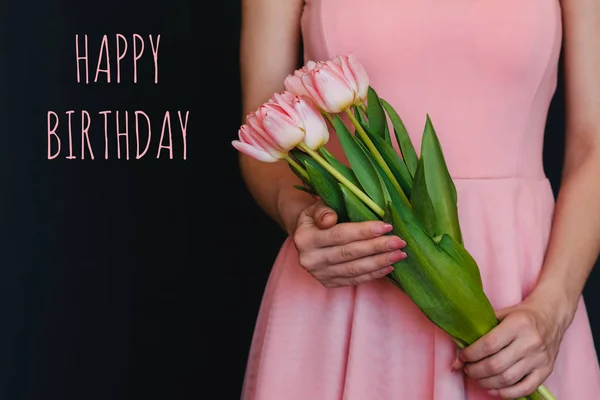 Buquê de flores de tulipas nas mãos de uma menina. Cartão de felicitações com texto Feliz Aniversário — Fotografia de Stock