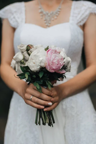 Bouquet de mariage avec pivoines roses et roses blanches dans les mains de la mariée — Photo