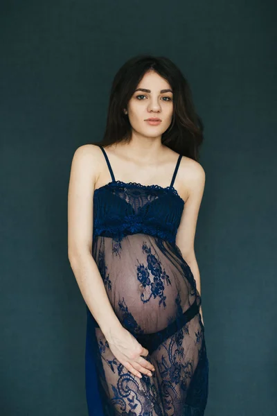 Pregnant young mother girl in a peignoir posing in a Studio — Stock Photo, Image