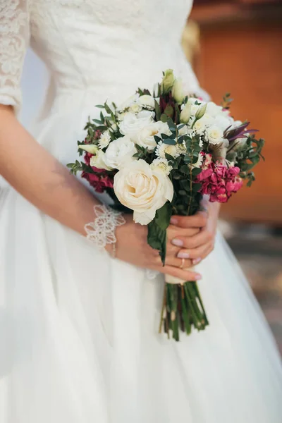Γαμήλια ανθοδέσμη με λευκά τριαντάφυλλα στα χέρια της νύφης — Φωτογραφία Αρχείου